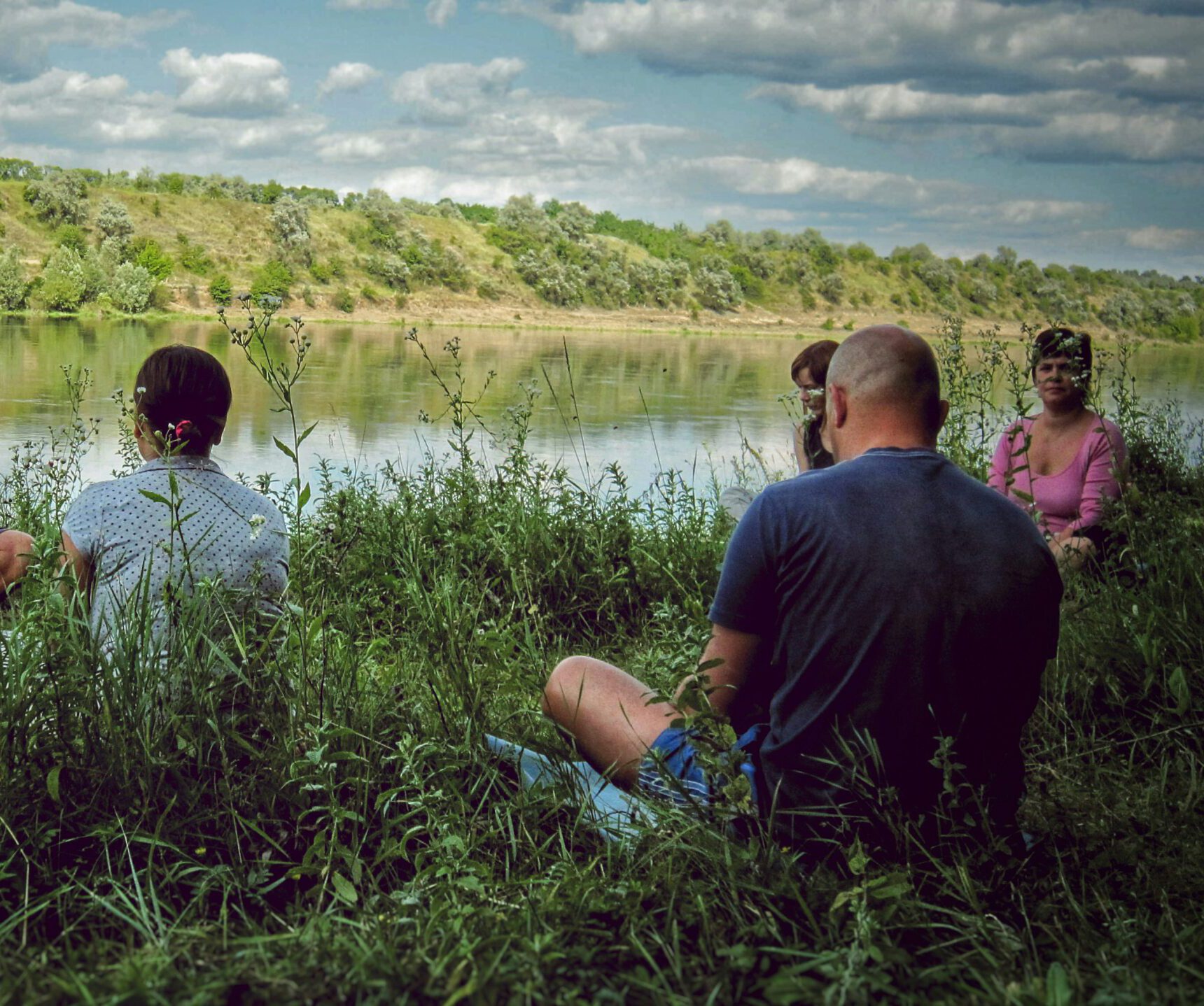 Menschen meditieren an einem Fluss